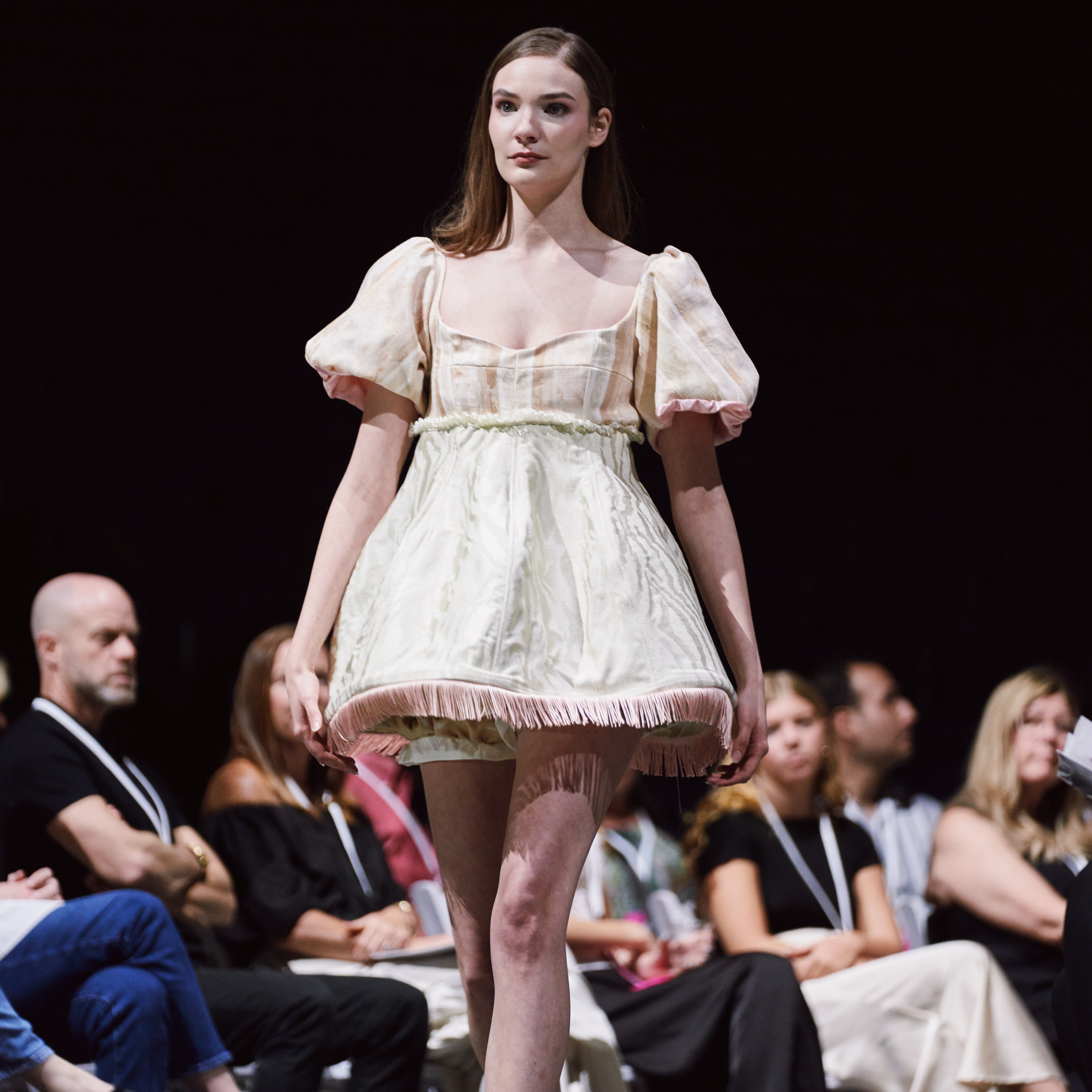 Female model walking on runway at fashion show