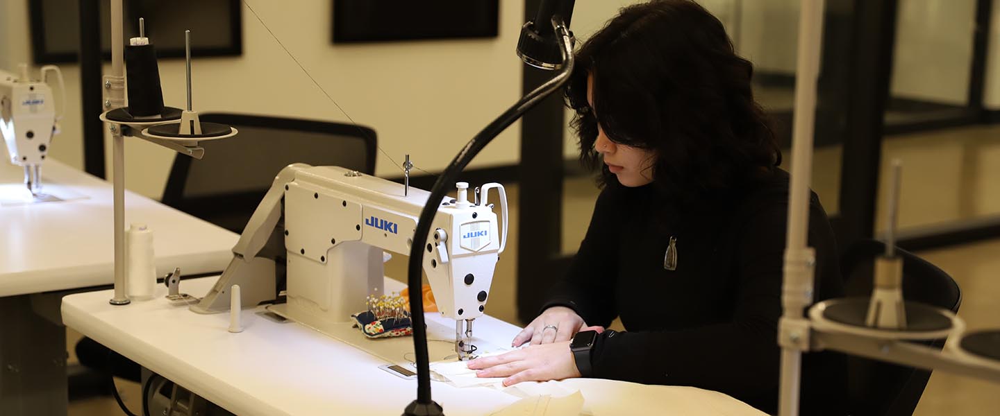 Fashion Design student sewing at a sewing machine