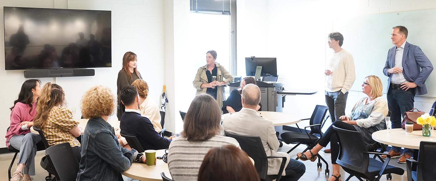 Group of peple gathered in discussion in a class room for O'More College