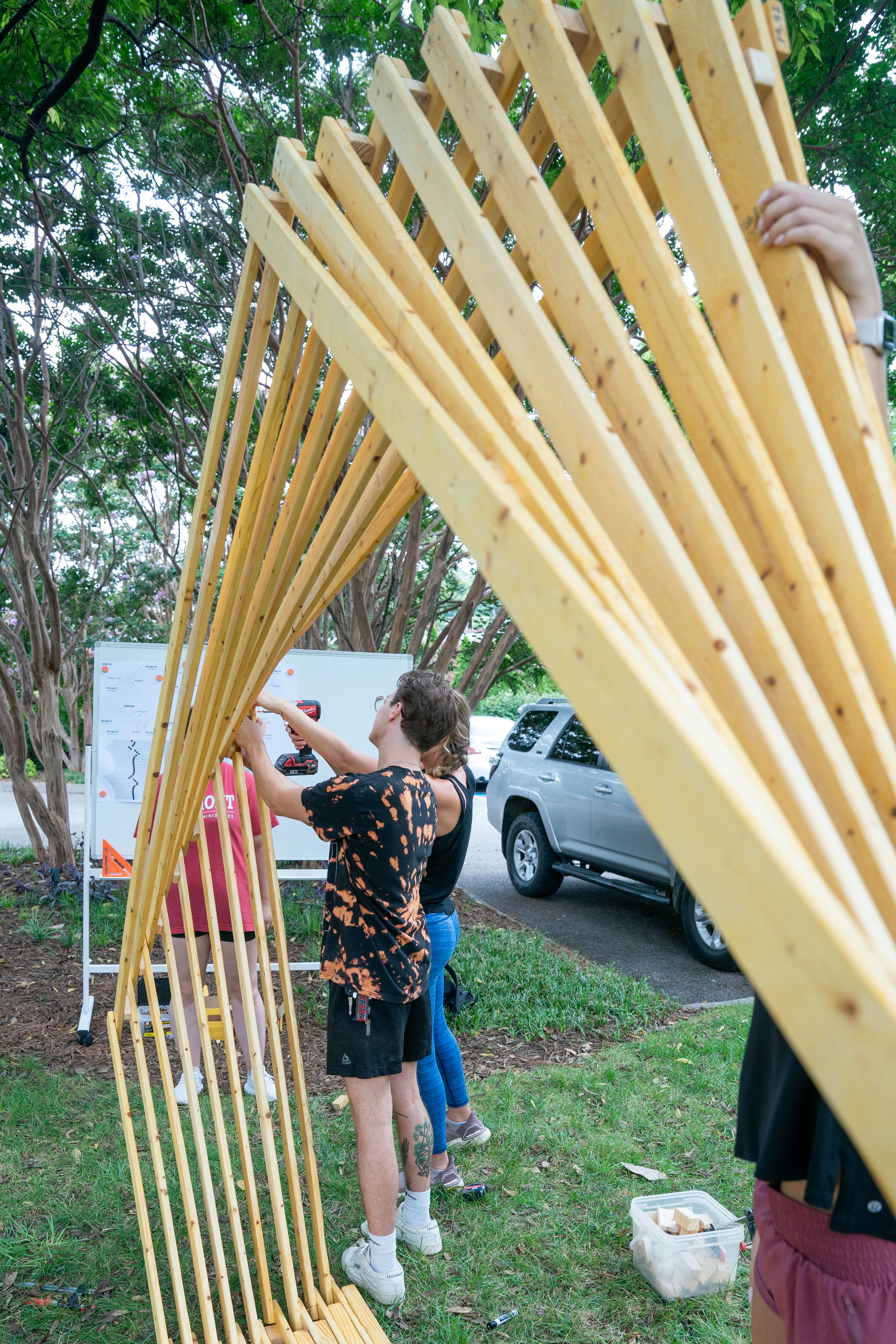 A picture of two people assembling the Twirl installation with a drill