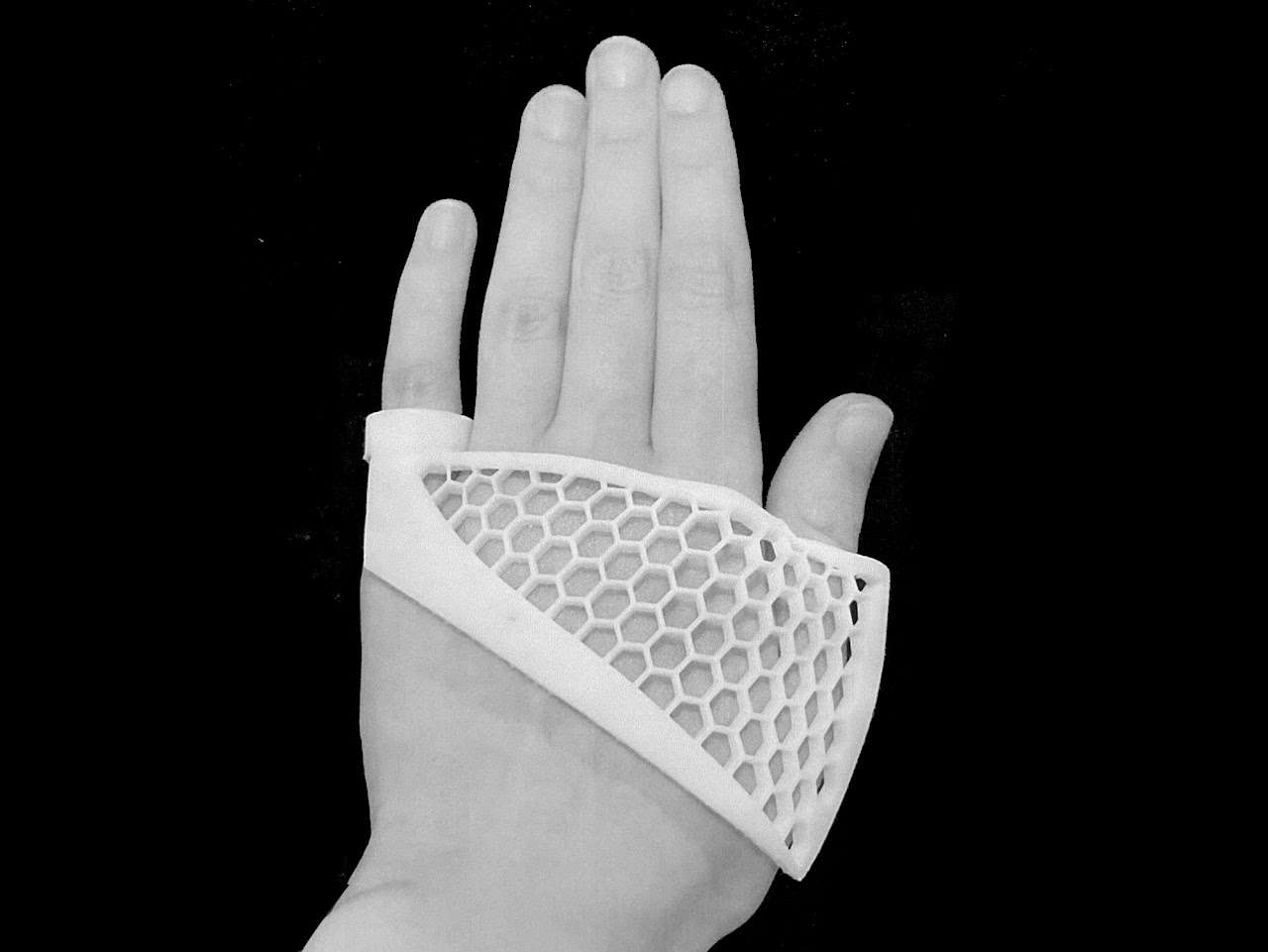 3d printed object on the back of a hand with a honey comb pattern