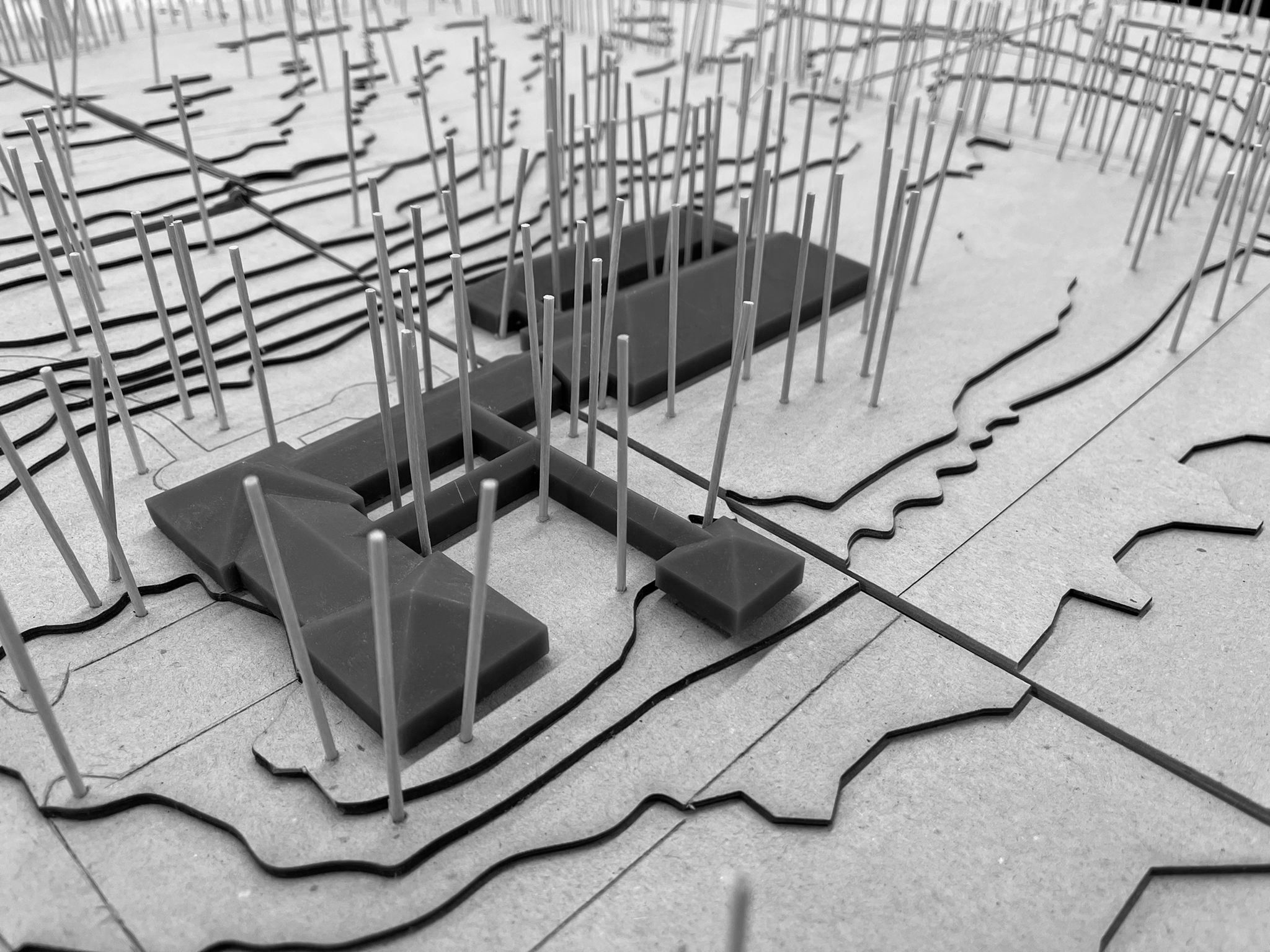 tight image of a building model with wood sticks representing trees