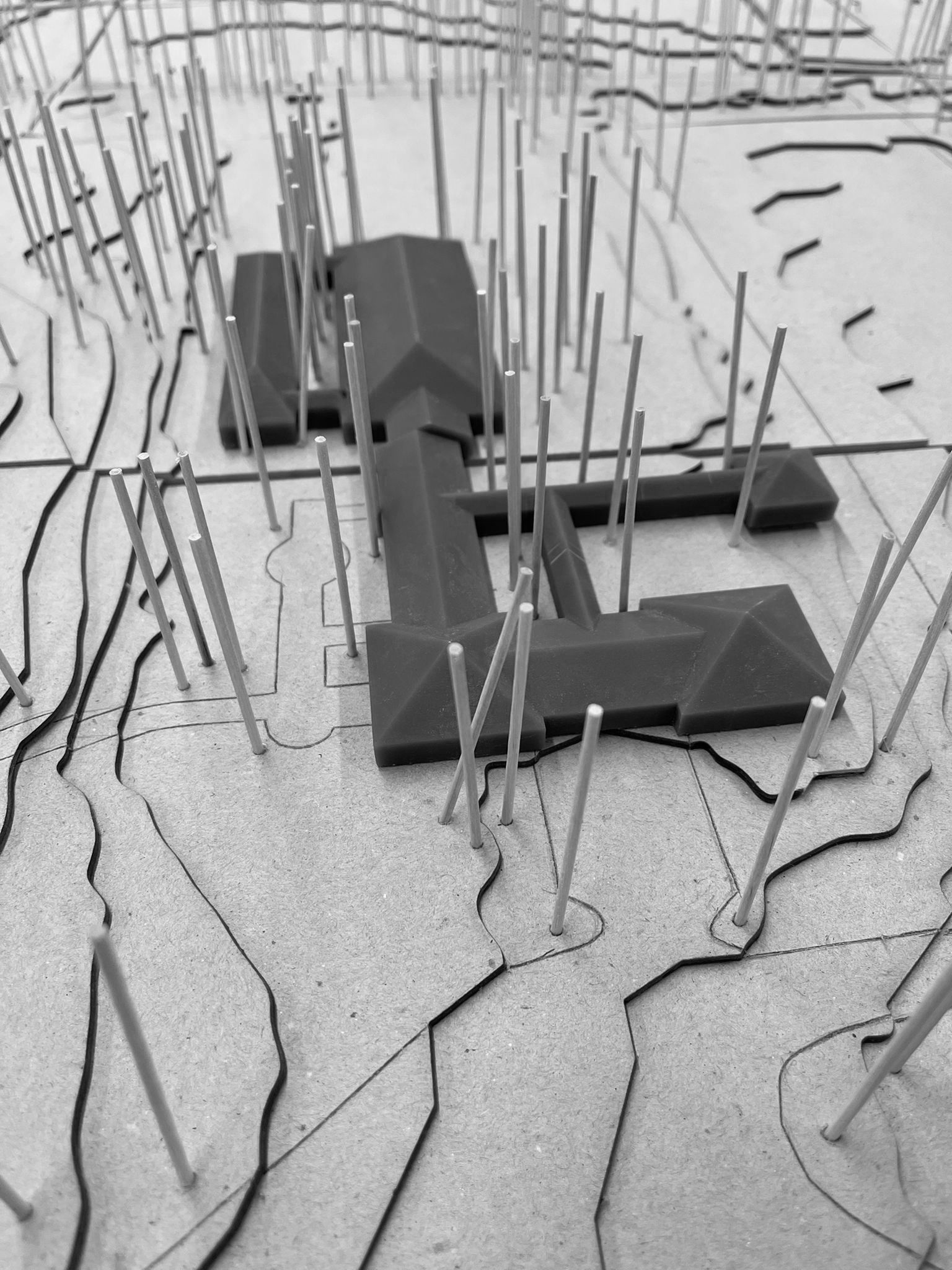 Close up image of a building model with wood sticks representing trees