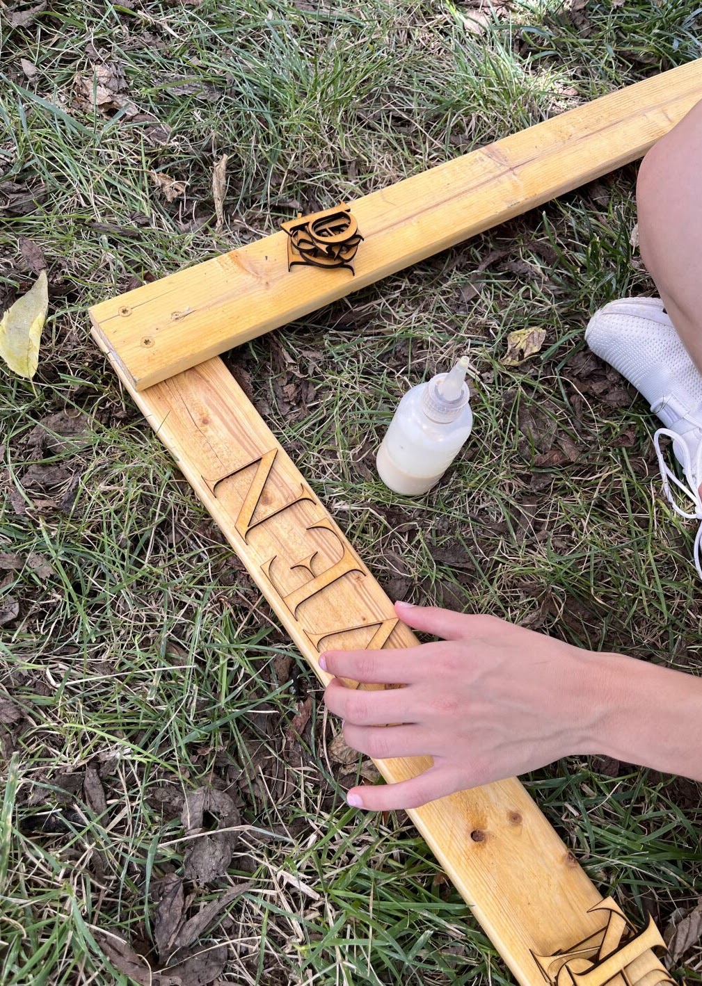 An upclose picture of a hand holding the squared off corner of two boards meetin