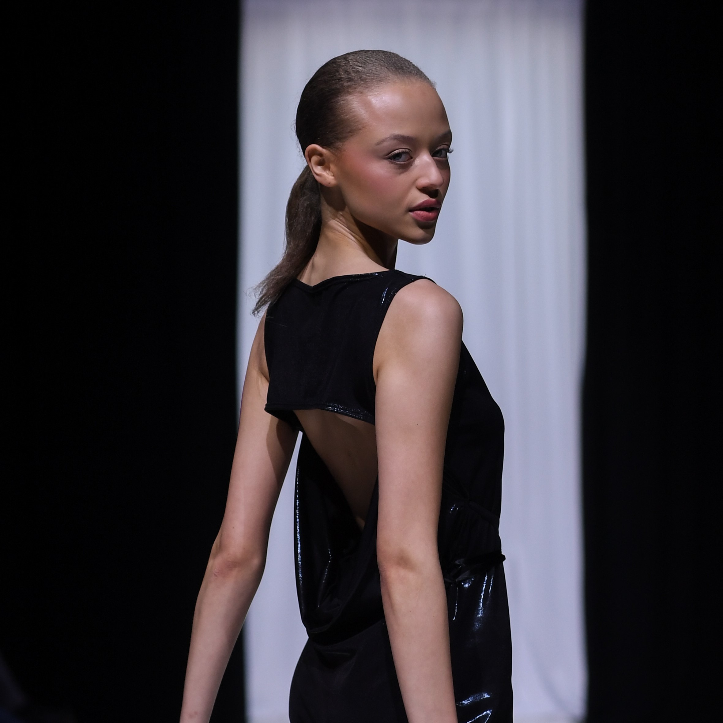 Female model walking on runway at fashion show
