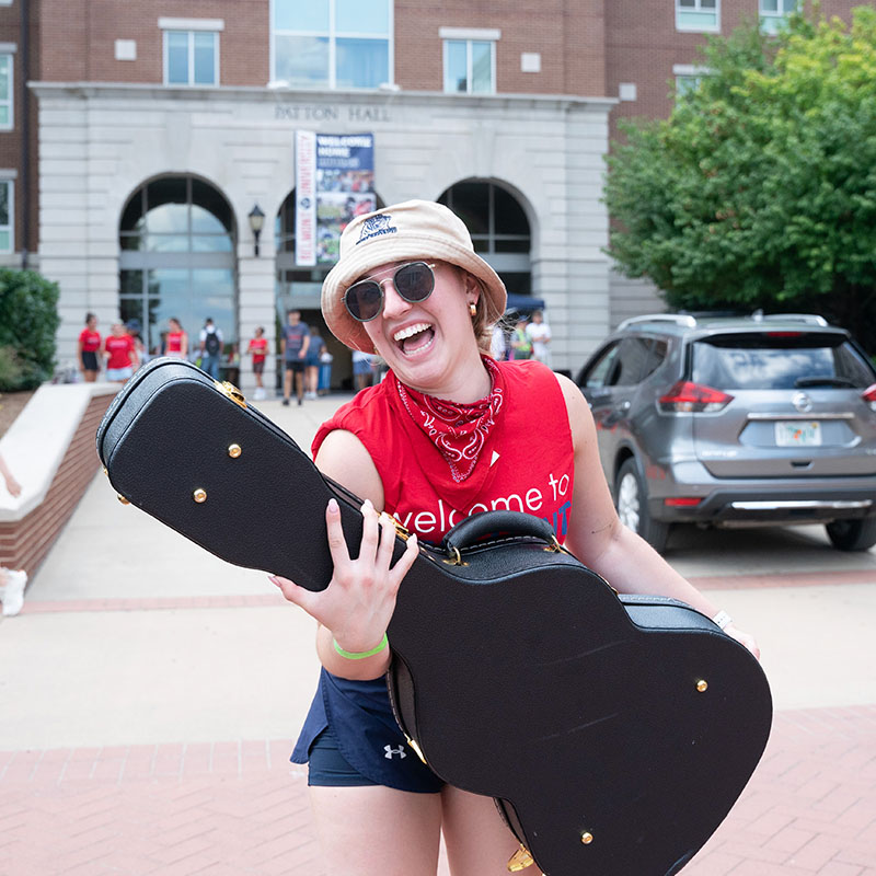 A student helping another student move in