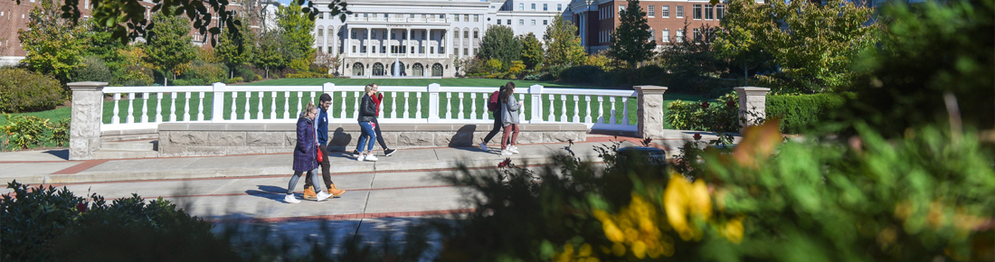 A photo of students walking through campus. The lawn and McWhorter Hall are seen in background.