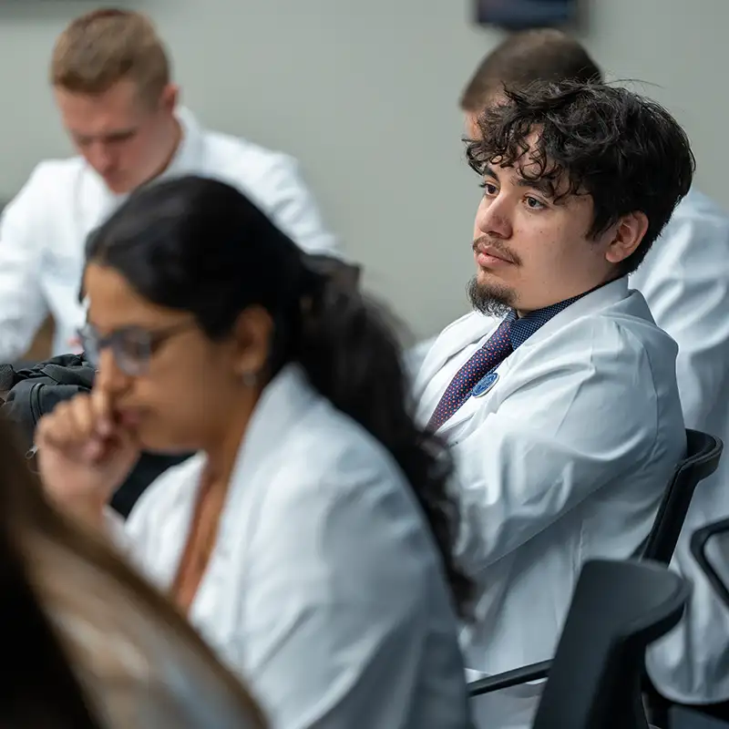 Students in lab coats in classroom setting