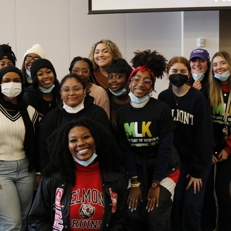 group of Belmont students huddle together and smile in MLK Joint Day of Service 2023 T-shirts
