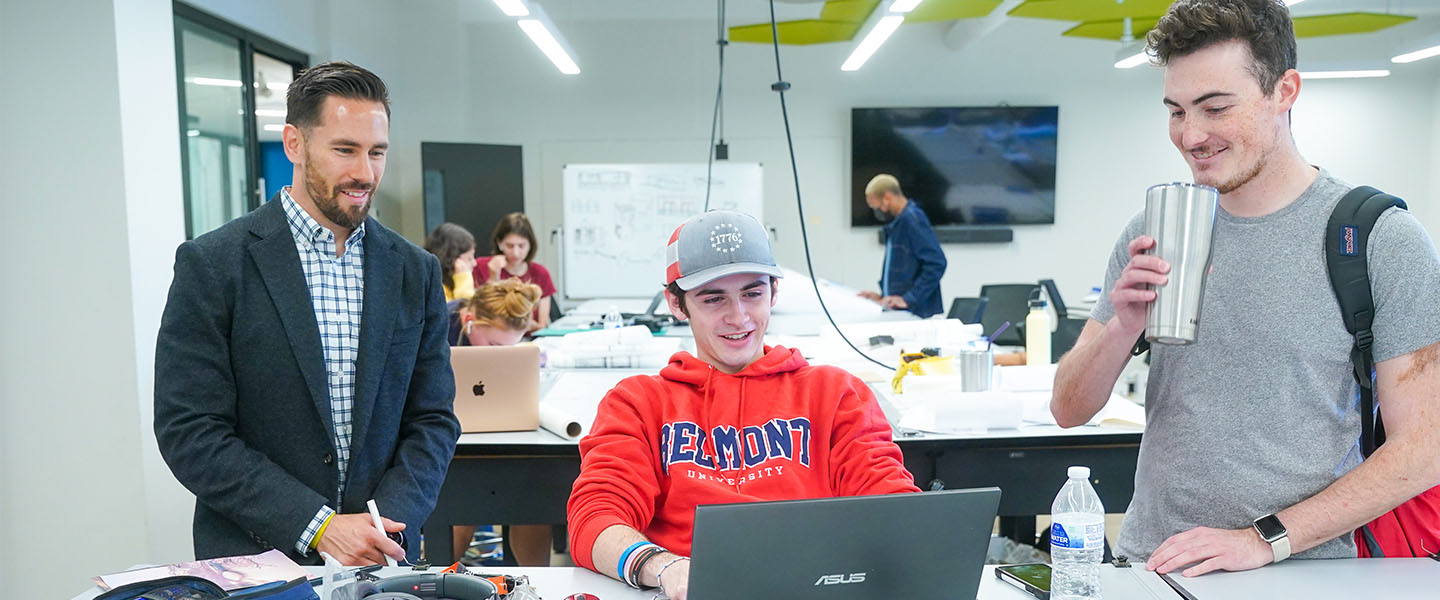 Two students and a professor working in a design class