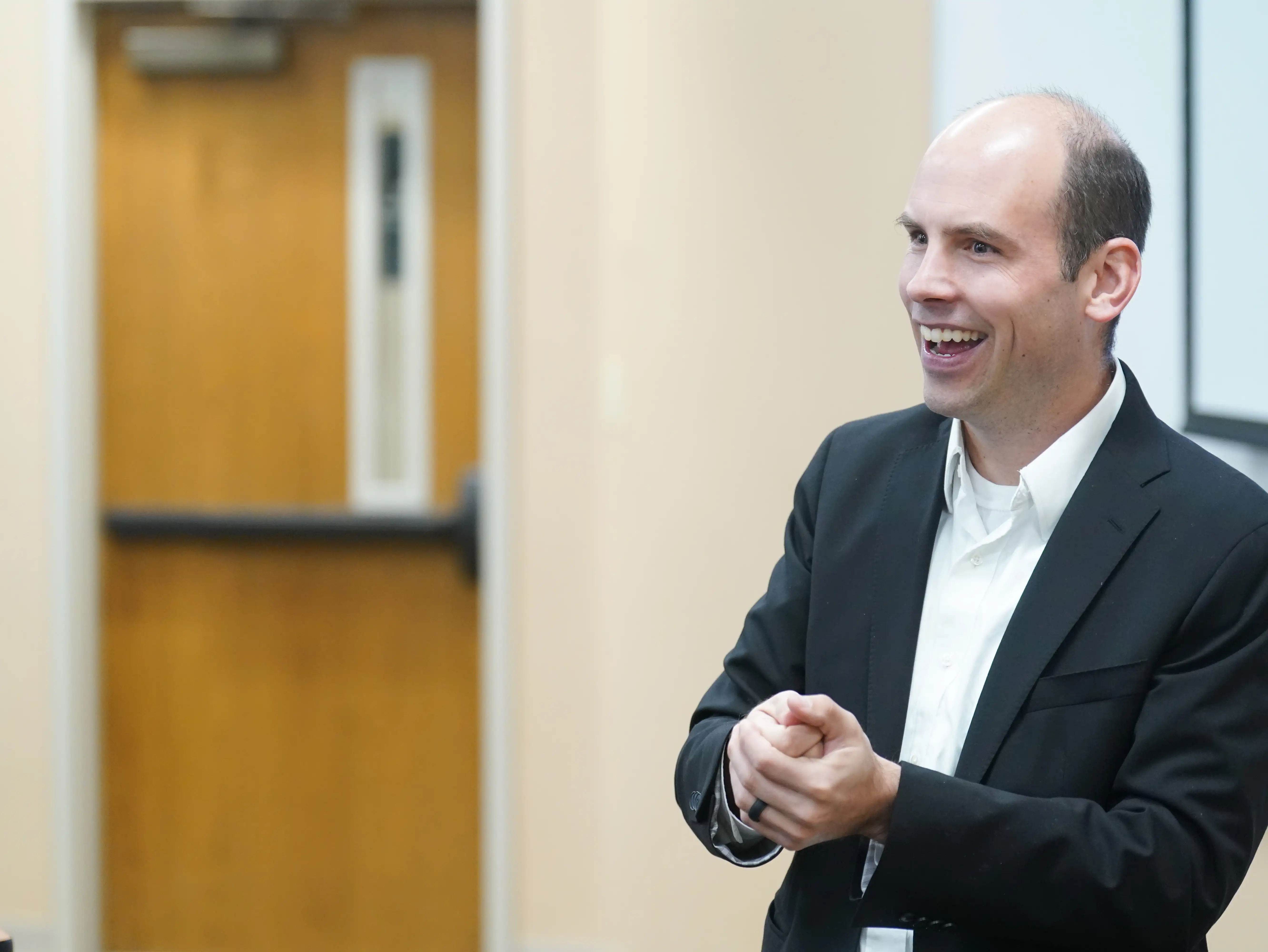 Professor smiling and engaging with an audience in a classroom setting