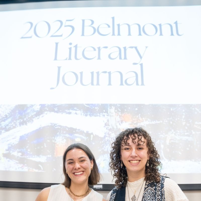 Two students stand in front of a projector reading "2025 Belmont Literary Journal"