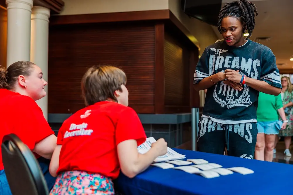 Student talking to campus representatives for Be Belmont Day