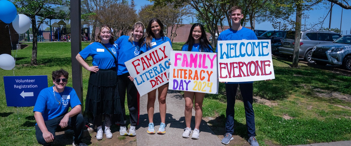 Students hold signs to promote Family Literacy Day