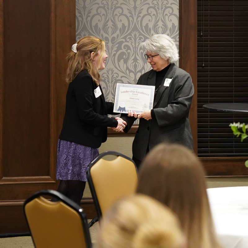 Dr. Bonnie Riechert hands out a student award