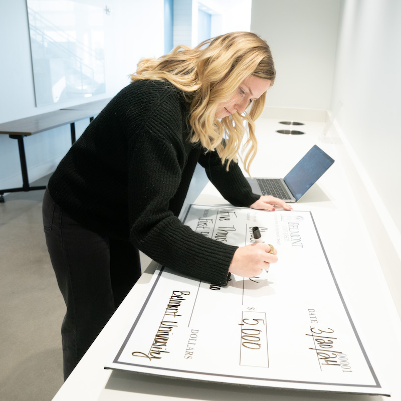 Maddie Bolser writes out first place check for $5,000