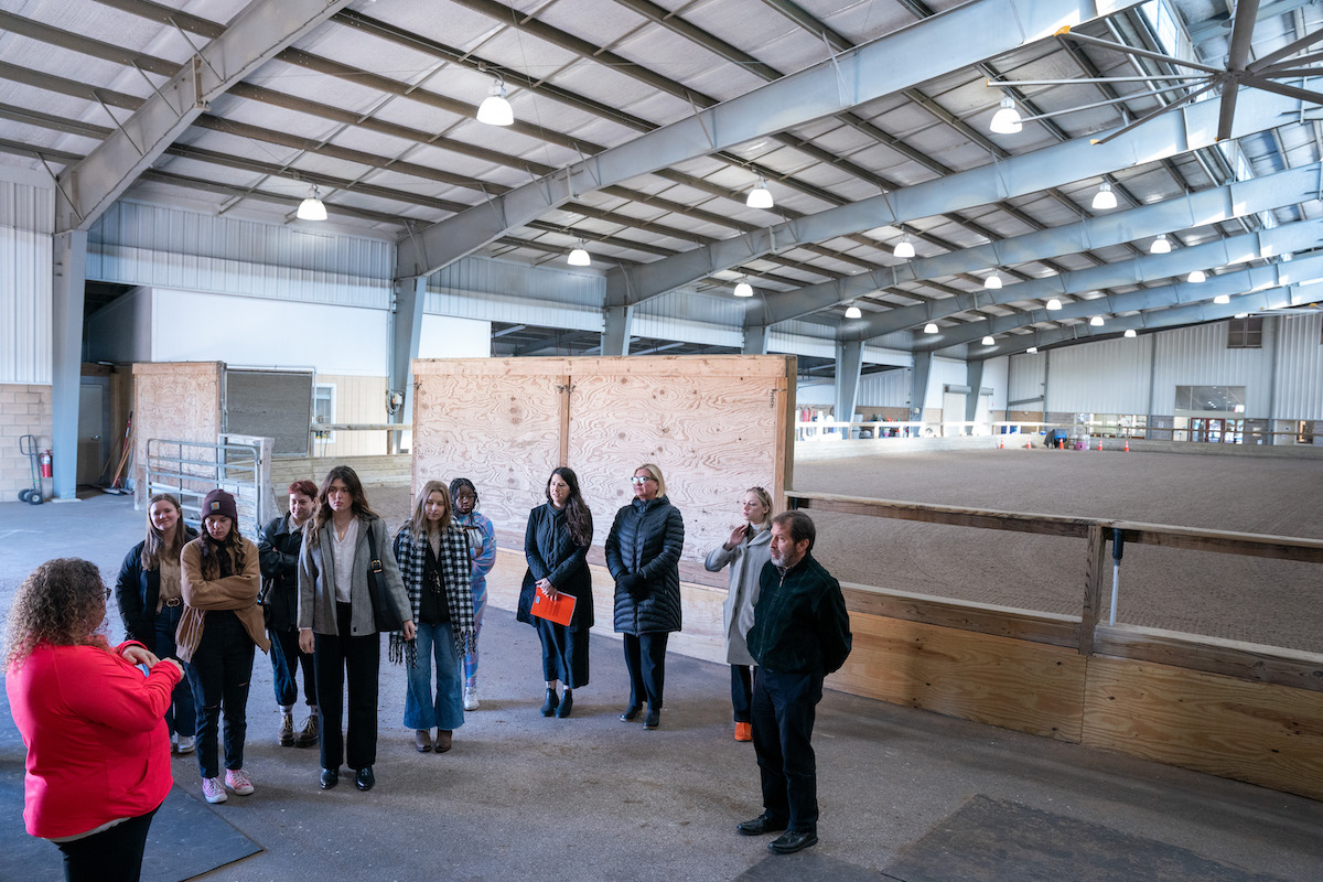 O’More students tour the indoor riding arena at Saddle-Up!, learning about the therapeutic horseback riding program.