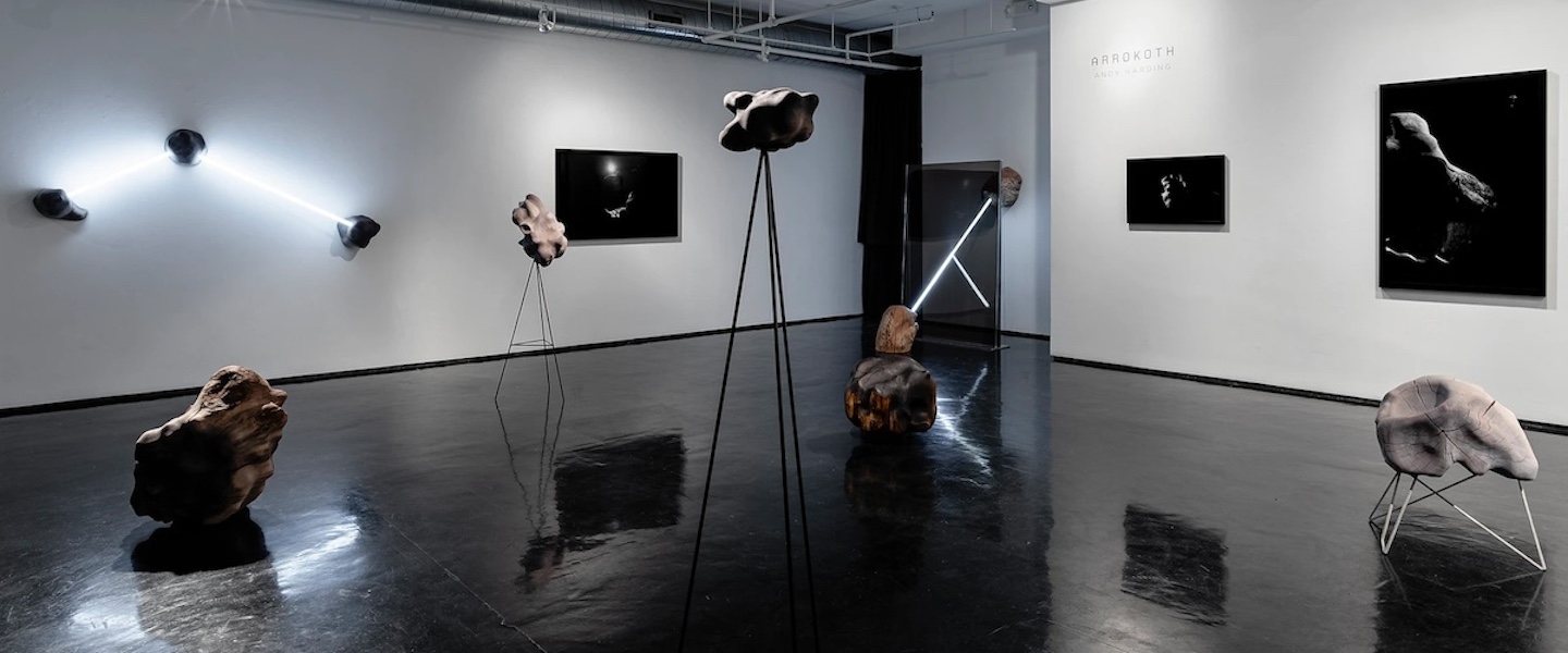 art piece displaying interconnected rocks, LED lights and wooden rods