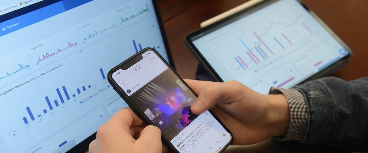phone in front of computer displaying social media analytics