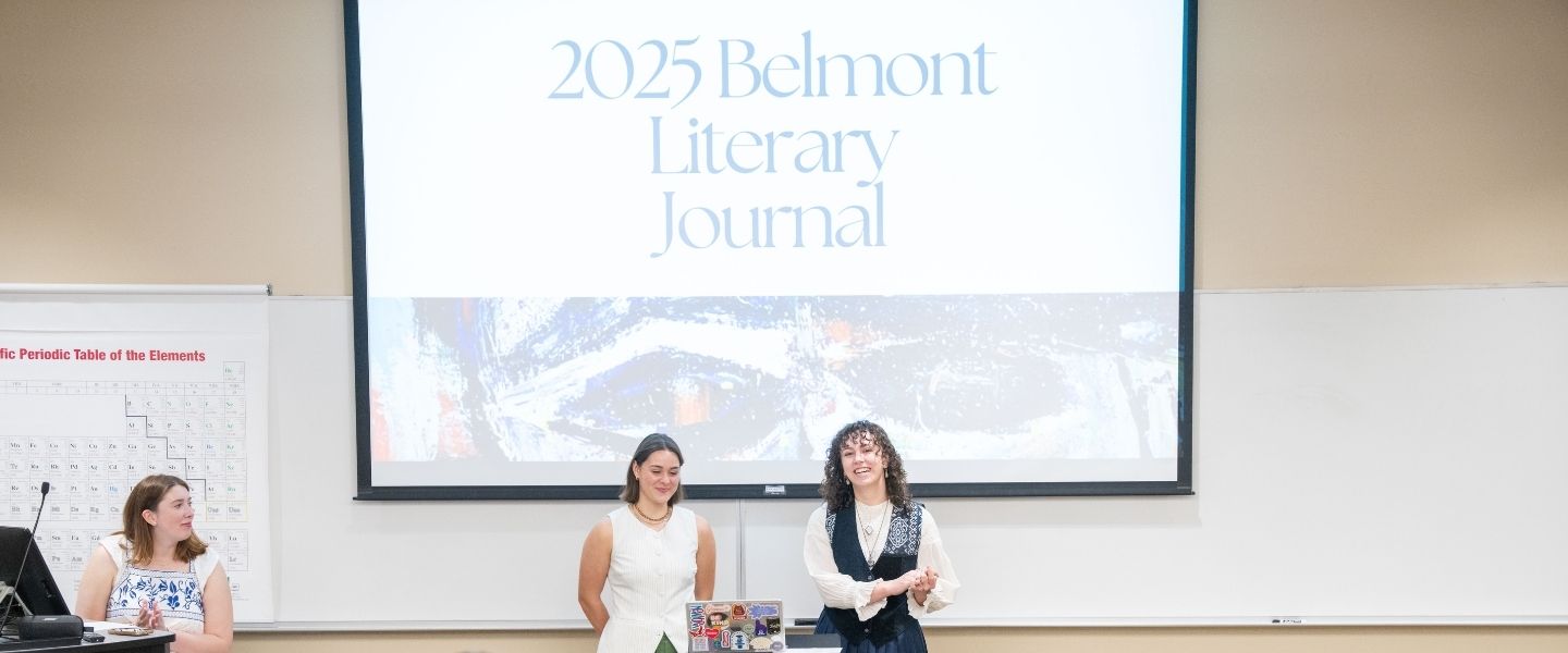 Two students stand in front of a projector reading "2025 Belmont Literary Journal"