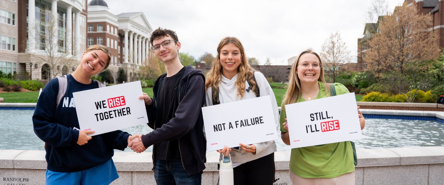 Students holding RiseStrong signs on campus