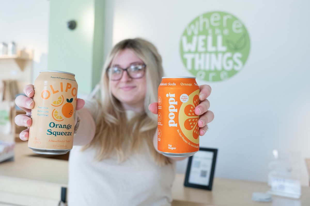 Woman holding Poppi beverages