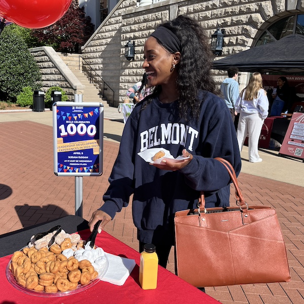 student smiling while selecting a donut