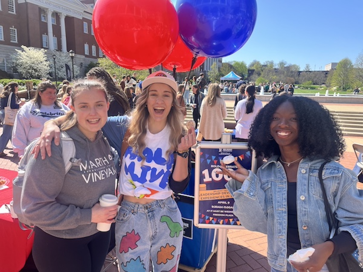 three students with donuts