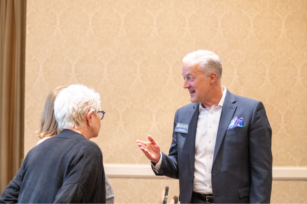 Dr. Mitch McCoy talks with two others