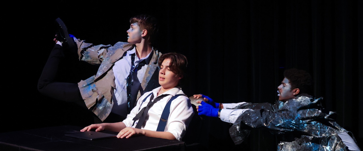 three actors in blue fish-like makeup looking off-stage
