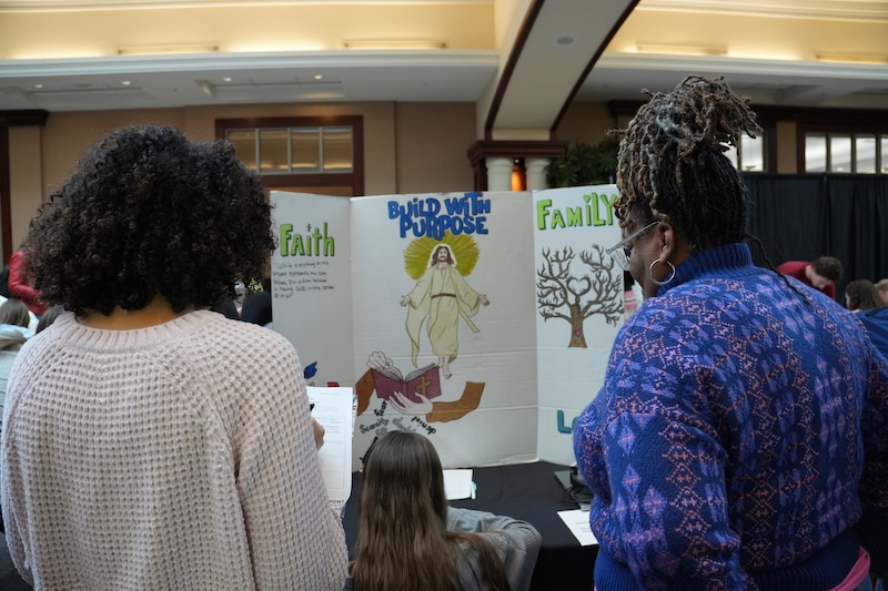 Two women looking at a project called "build with purpose"
