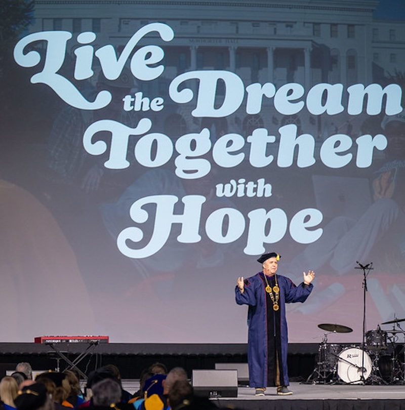 Dr. Jones in front of screen that reads "Live the Dream Together with Hope"