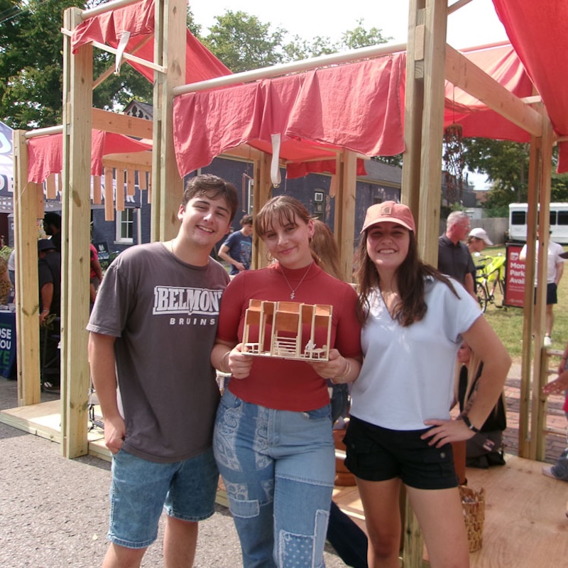 students from winning team in front of their design