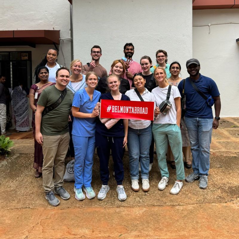 Students and faculty pose with Belmont Abroad sign