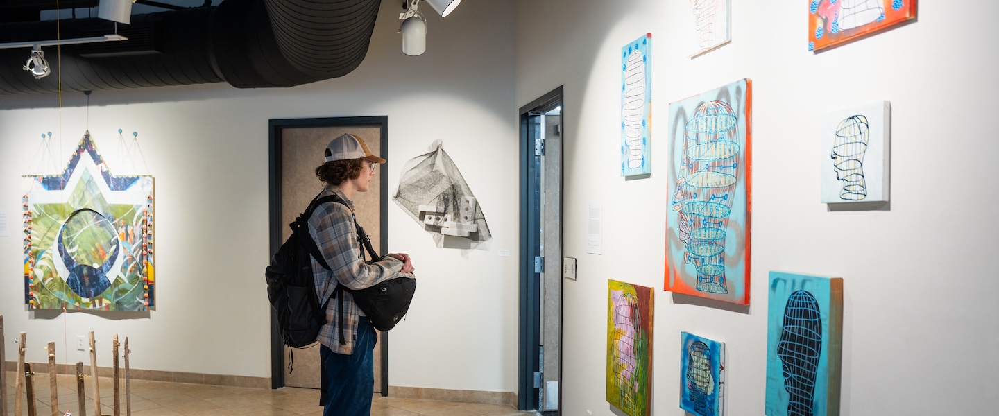 student looks at art within the gallery