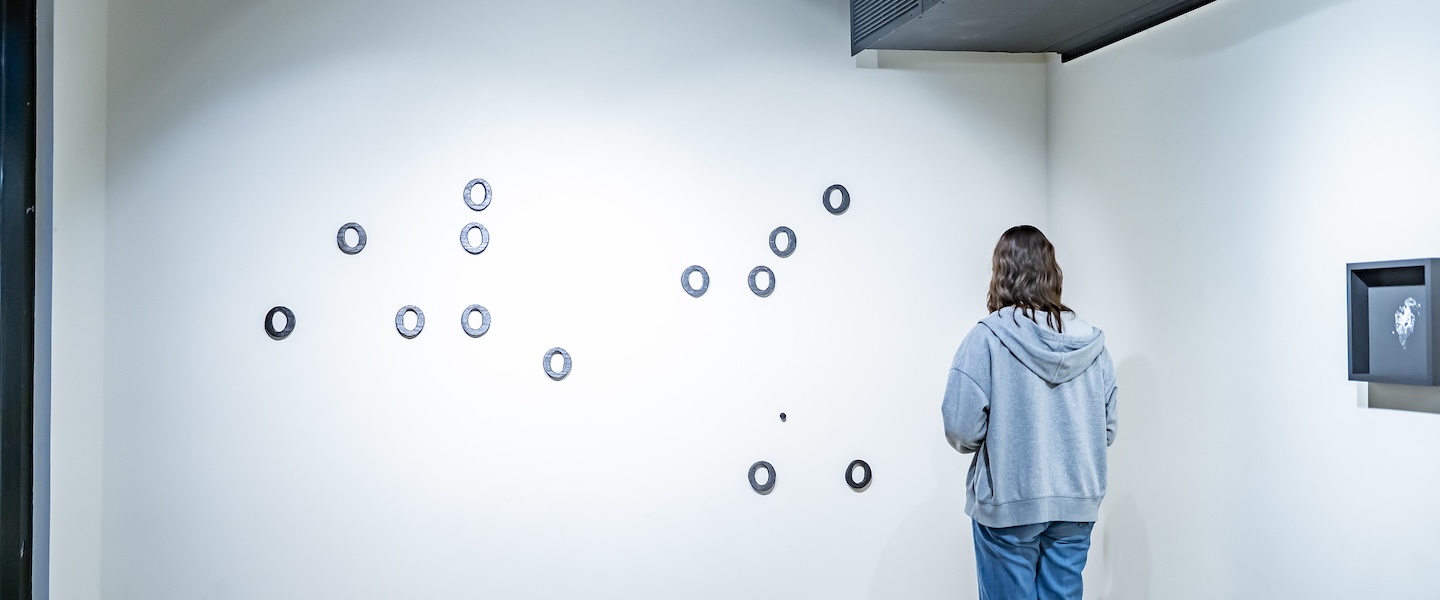 someone looking at two of the pieces in the gallery