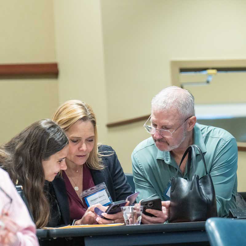 Three people gathered at symposium