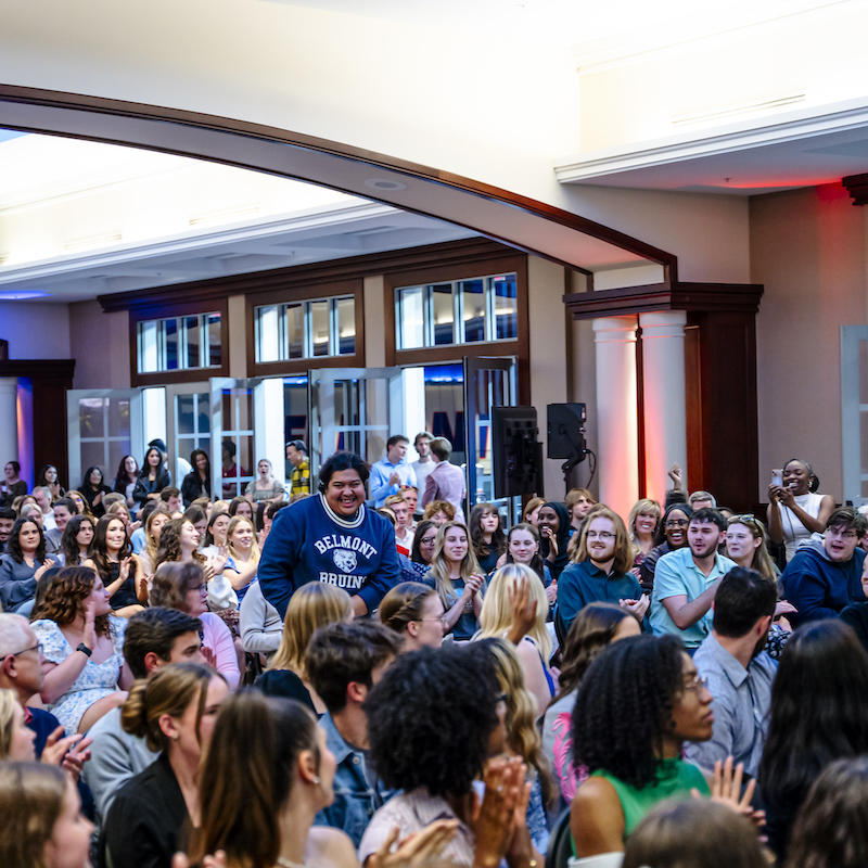 Alt TextStudent standing among crowd of peers