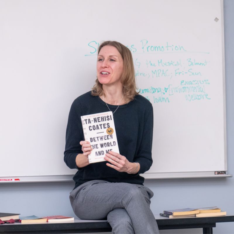 Dr. Caresse John holding a book