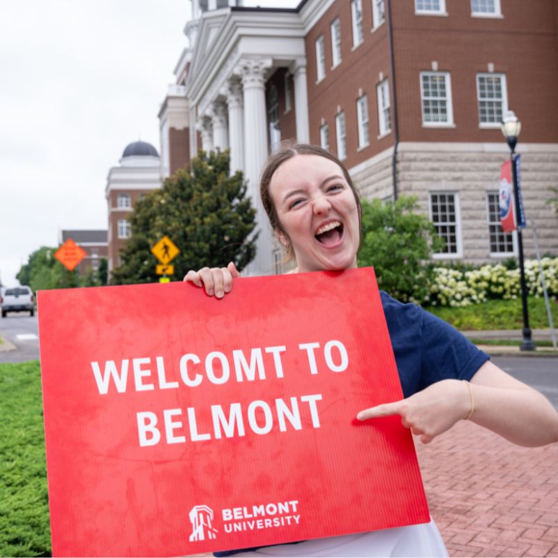 Student holding sign reading "Welcome to Belmont