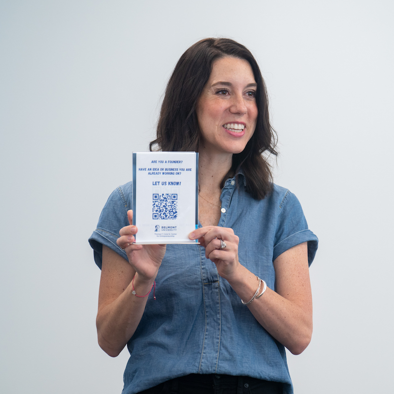 Woman smiling while holding QR code