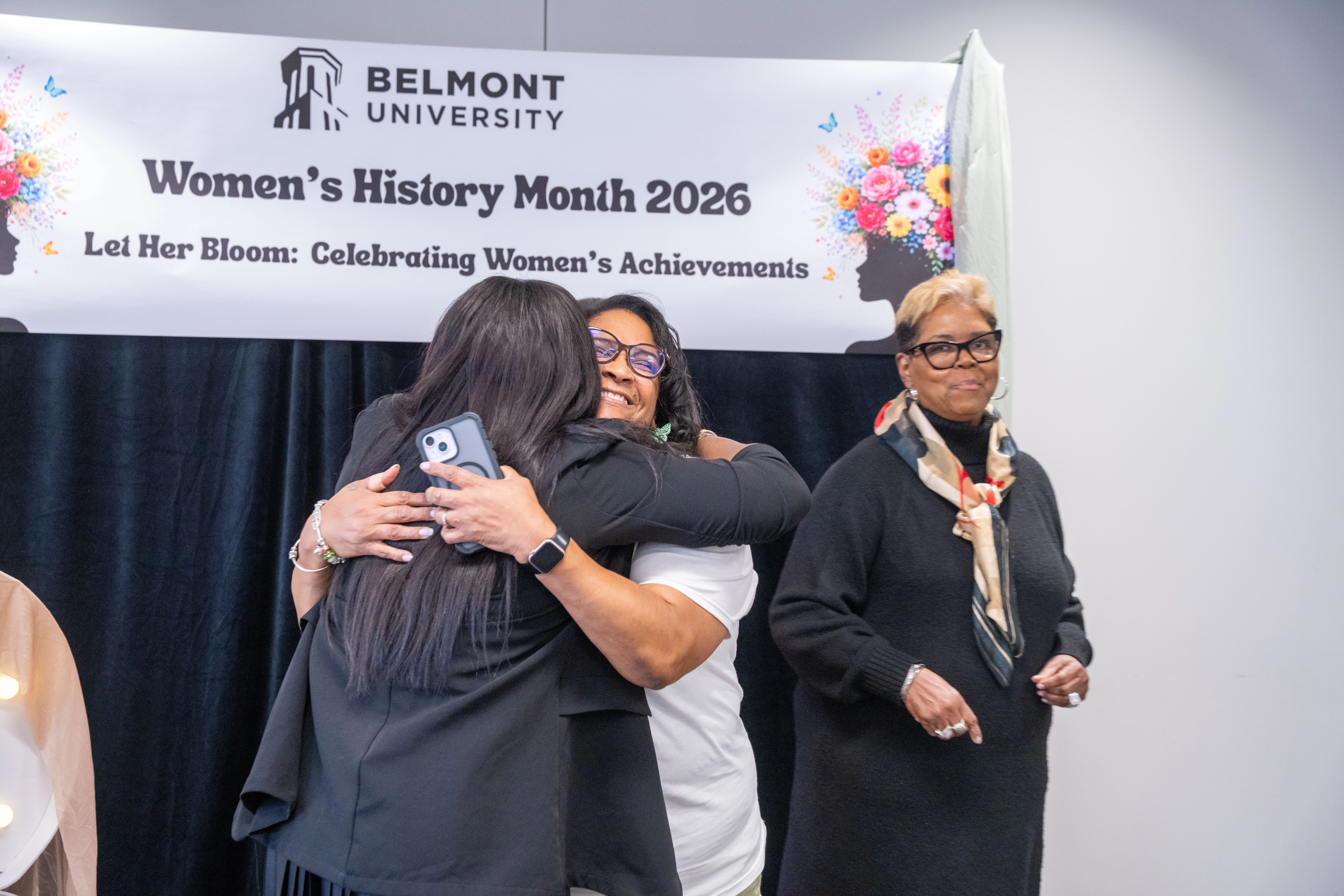 Women hugging at In Her Honor Luncheon