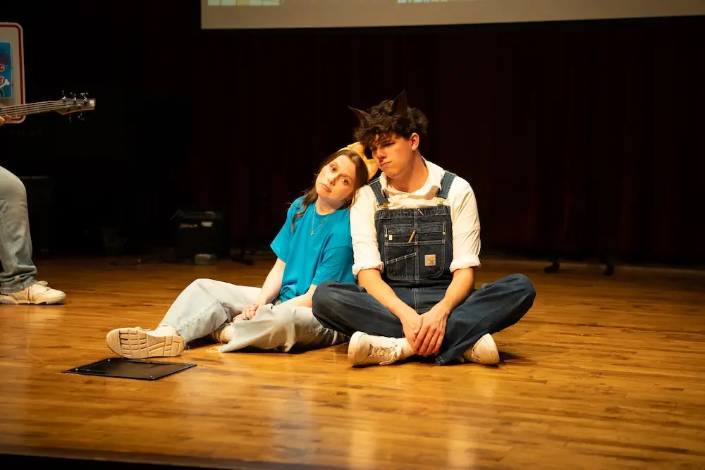 two actors sitting on stage