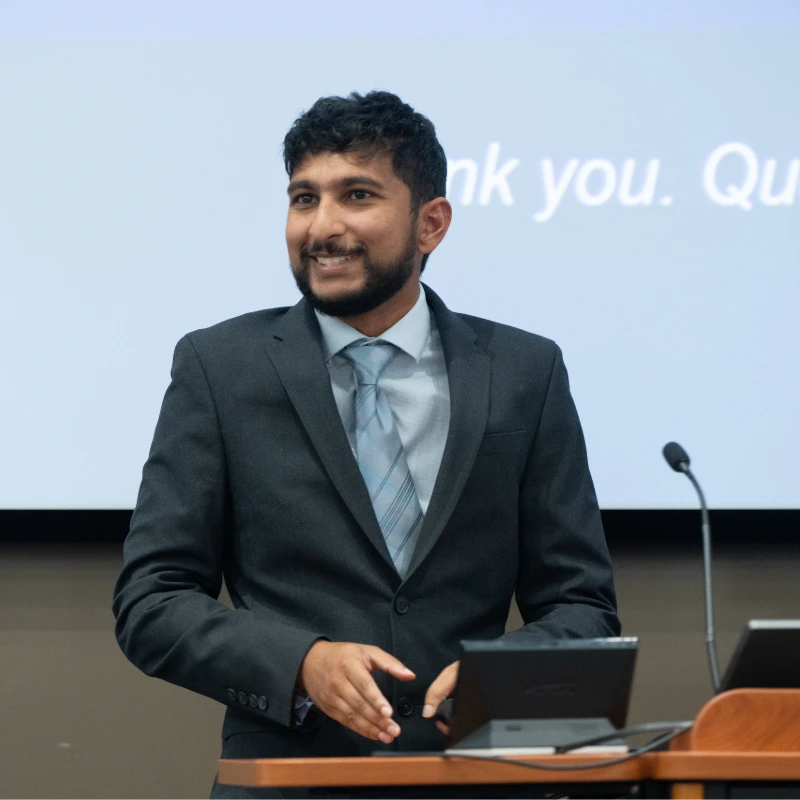 Student researcher Zain Hussain smiles and takes questions following his presentation on non-linear visual field progression in glaucoma.