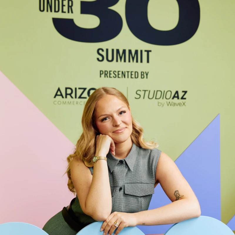 Abby Stevenson-Greiss posing with a sign at the Forbes Under 30 event