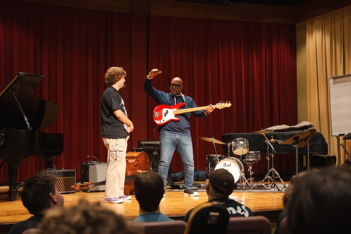 McBride shows a student how to play guitar