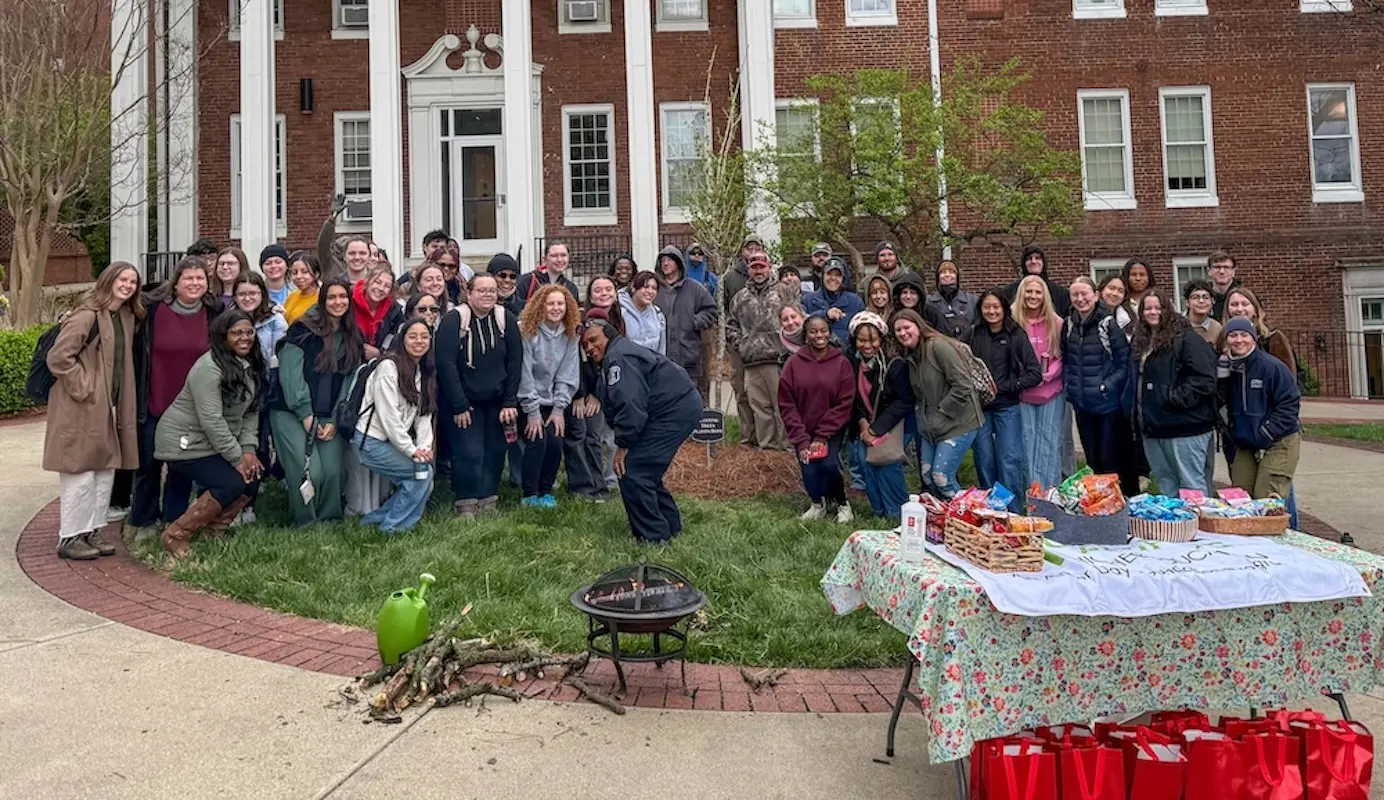 Students and staff take group photo with newly planted tree
