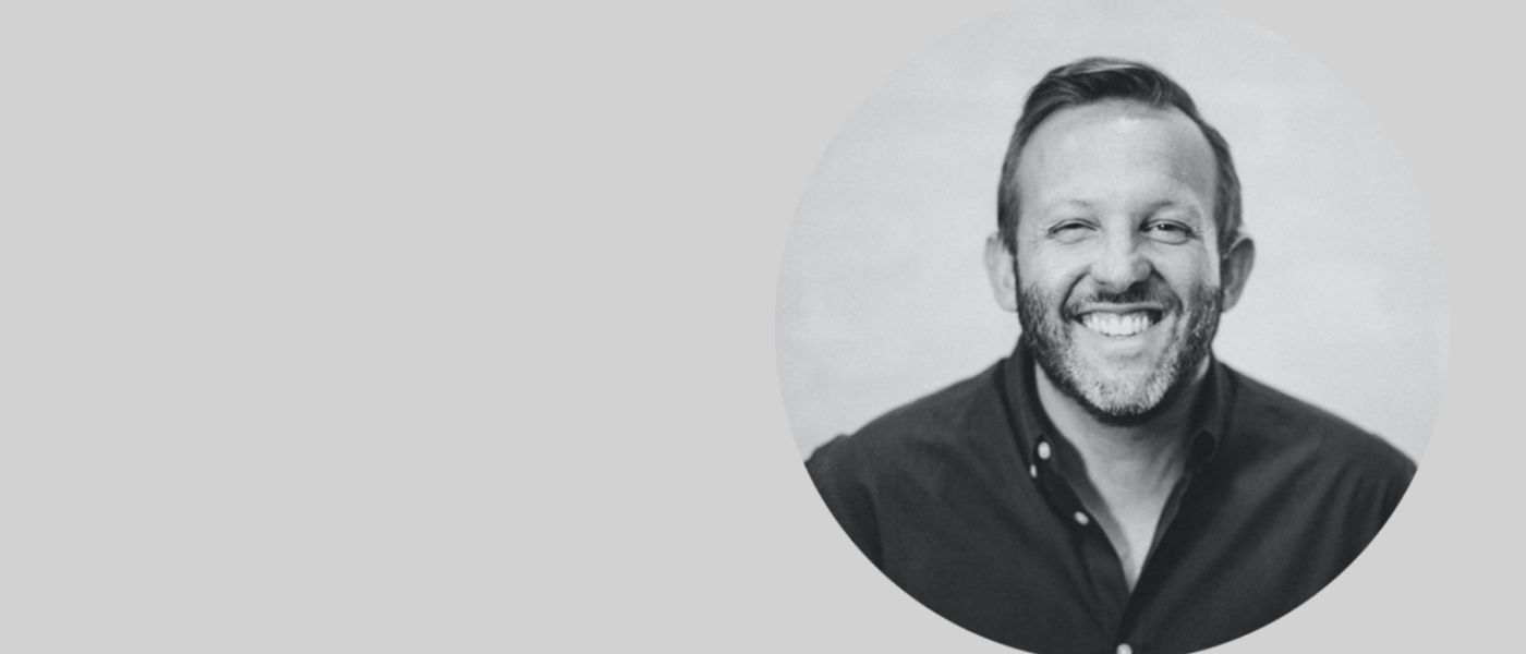 Headshot of Andrew Greer on grey background