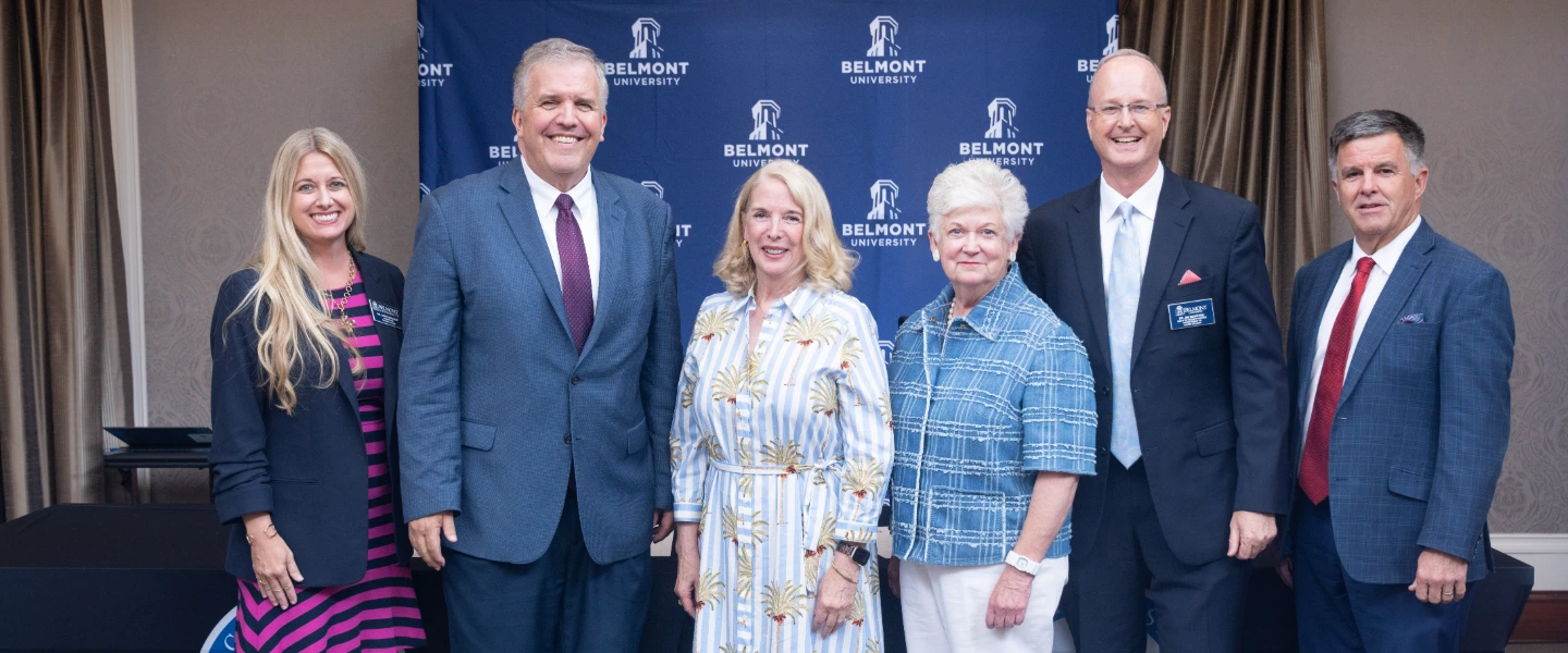 Belmont University event group photo: Six smiling professionals, three men and three women, in front of a logo banner.