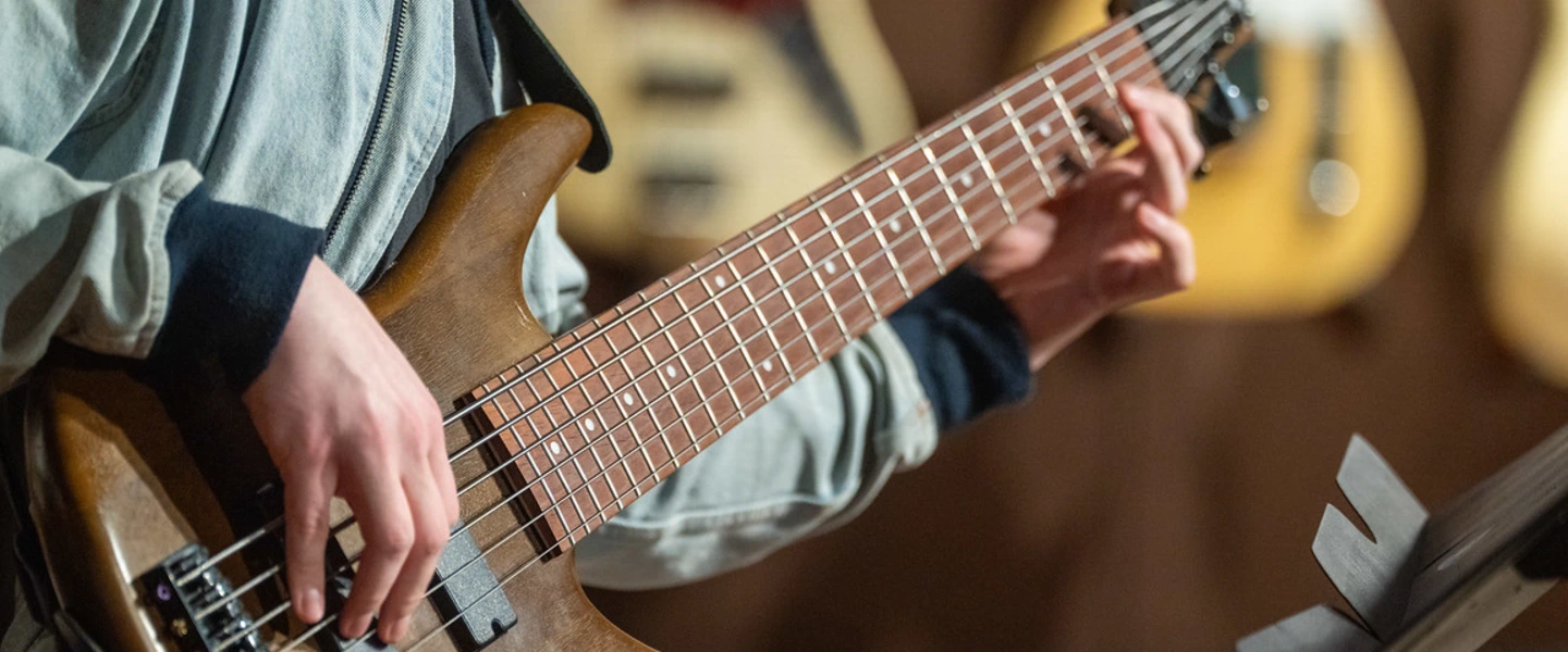 student holding a guitar